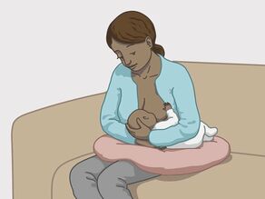 Przykład karmienia piersią nr 2: matka siedzi, natomiast dziecko leży obok niej.
